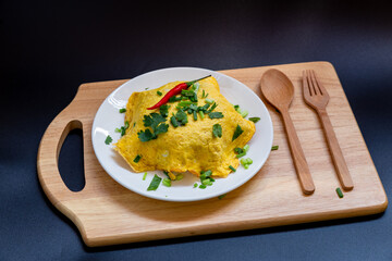 Omelette in white plate isolated on black background.