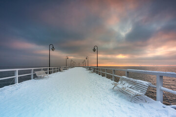 Beautiful wooden pier in Gdynia Orlowo at snowy winter, Baltic Sea. Poland