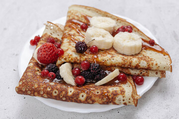 Russian pancakes or blini with berries in white plate. Top view. Pancake week. Shrovetide. 