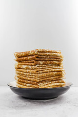 Russian Maslenitsa, Shrovetide, pancake week, carnival, shrove, pancake day. A stack of pancakes on plate, on light background, close-up. Soft focus.