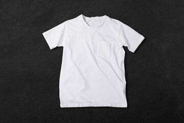 Basic white Tshirt on grey concrete surface. Mock up for branding t-shirt with pocket. 