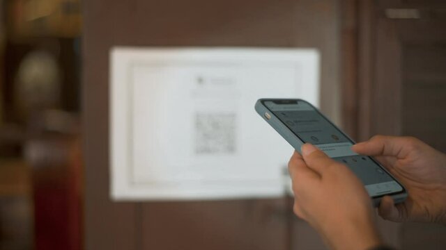 Bangkok , Thailand - January  24, 2021: close up woman hand is holding smartphone to scanning QR code "Thai Chana&rdquo; Application for  COVID-19 Prevention in restaurant