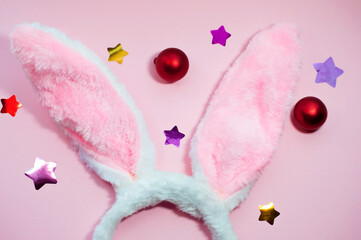 Easter pink background fluffy pink bunny ears decorated with confetti stars and red balloons