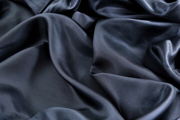 Fototapeta premium part of the dark fabric texture of the fabric for the background and design of the artwork, a beautiful crumpled pattern of silk or linen. A crumpled piece of cloth