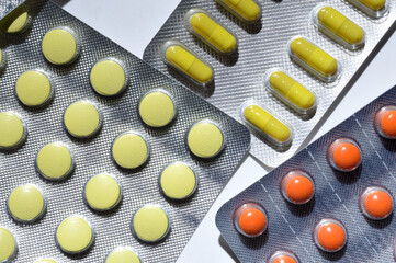 Medicine pills are packed in blisters, lie on a light background. close-up.