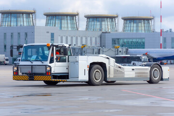 Aerodrome tow tractor is driving along the steering paths at the airport.