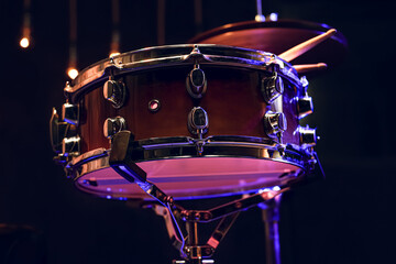 Fototapeta na wymiar Snare drum and drumsticks close up in dark.