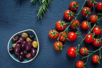Mediterranean cuisine -  delicious fresh food -  piccolo tomatoes, Italian ciabatta, Kalamata olives, Maroccan Salted Olives, rosemary and black grapes.