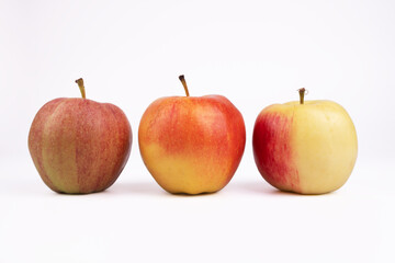 three apples of different colors lie parallel