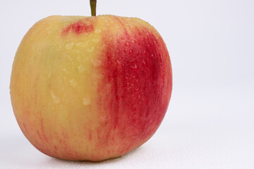 close-up apple the left half of which is yellow and the right half is red
