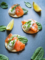 Smoked Salmon appetisers - delicious fish, black pepper, cream cheese, green garnish.