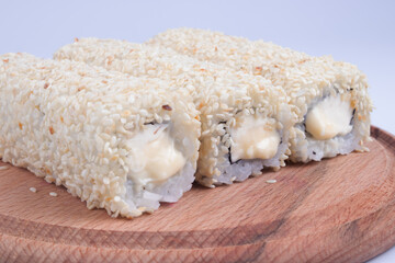 three long rolls with sprinkles on the board at an angle view