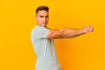 Young handsome caucasian man isolated stretching arms, relaxed position.