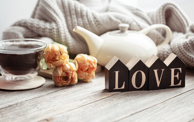 A cozy composition for Valentine's Day with the decorative word love and decor details.