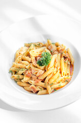 penne amatriciana tomato and ham sauce pasta on white table