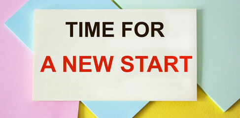 TIME FOR A NEW START written on a colored sticker and a colorful background