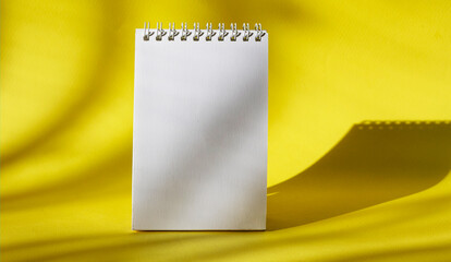 Fototapeta na wymiar White notepad on a yellow background to write something