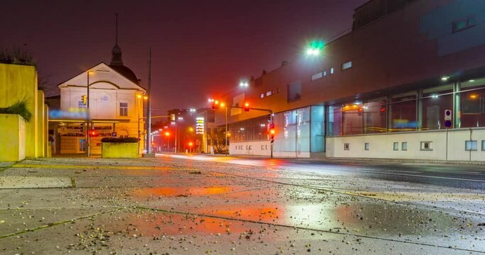 Timelapse of traffic with light trails of cars and city lights at night on a wet road.