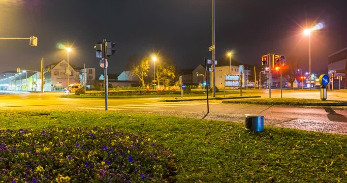 Timelapse of traffic with light trails of cars and city lights at night on a wet road.