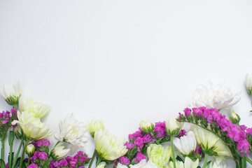 Pink statice and white chrysanthemum flowers on a white background. Top view. Copy space. Space for the text. The concept of the holiday.