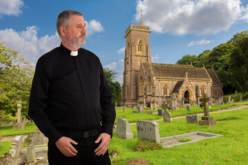 A priest stands outside the historic St Etheldreda's Church in Wales. The older man is wearing a...