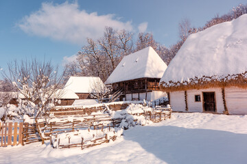 Traditional Romanian village in Transylvania with old house straw roofing covered with snow in a cold day