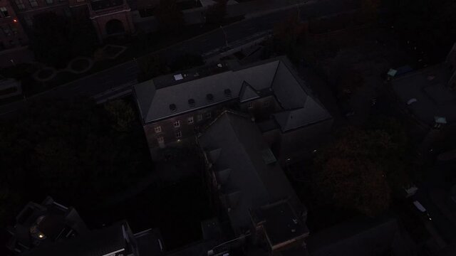 2.7K Aerial reveal shot looking east over Toronto directly at parliament building with beautiful purple/pink sky during sunset