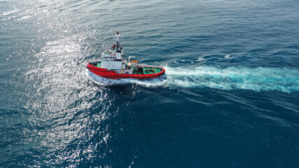 Aerial drone photo of tug boat cruising in high speed near port of Piraeus, Attica, Greece