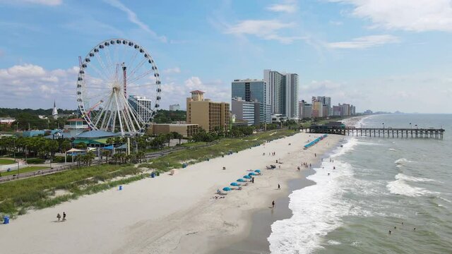 Myrtle Beach Skyline, South Carolina USA. Aerial View of Grand Strand Beachfront Ferris Wheel and Pier on Sunny Day, 60fps Drone Shot