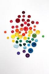 Group of plastic colorful buttons on white background. Rainbow colors red, orange, yellow, green and blue tailor texture