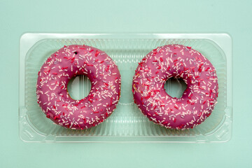 Donuts in plastic packaging. On a blue background. Sweet dessert.