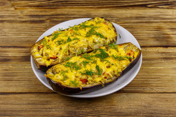 Baked stuffed eggplants on a wooden table. Healthy food and dieting concept