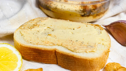 White bread smeared with hummus close up.