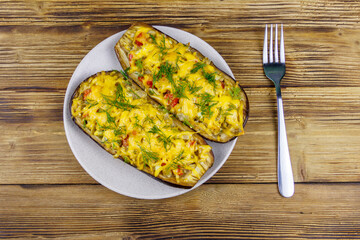 Baked stuffed eggplants on a wooden table. Top view. Healthy food and dieting concept