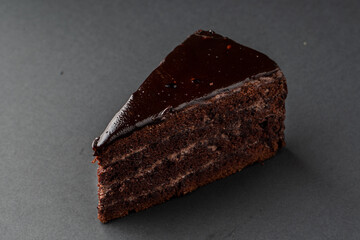 A single slice of moist brownie cake in a smooth chocolate glaze