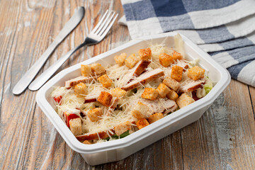 Pandemic food delivery: classic caesar salad with grated cheese and grilled chicken