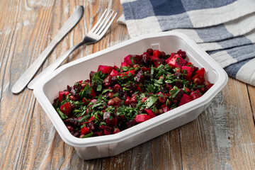 Food delivery during social distancing: vinaigrette in a box, no lid, wooden table