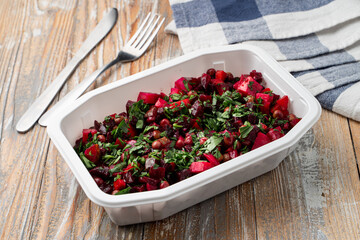 Food delivery during social distancing: vinaigrette in a box, no lid, wooden table