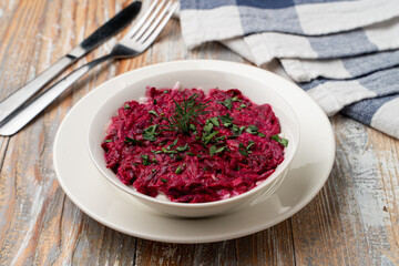 Beetroot casad with garlic and nuts on a country wooden table, light clean photo