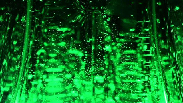Abstract green liquid with rising bubbles pattern on dark background