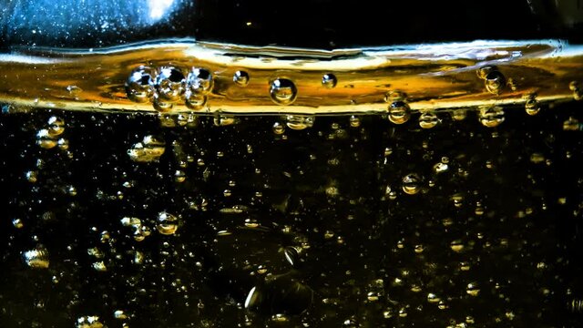 Abstract golden liquid with rising bubbles pattern on dark background