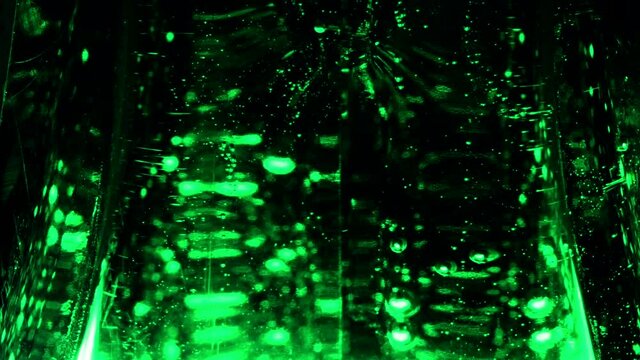 Abstract transparent green liquid with rising bubbles pattern on black background