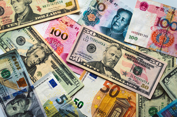 Fototapeta na wymiar Background from different banknotes. Dollars, euros, yuan.