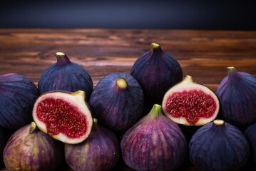 Tasty figs in a bowl on wooden background. Top view.