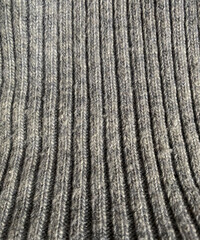Knitting, seams and furrows. Grey texture. Material