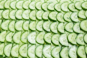 Fresh green slices of cucumber as background.