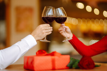 Clinking glasses with red wine. Romantic dinner. Valentines day, romantic date and holidays concept.