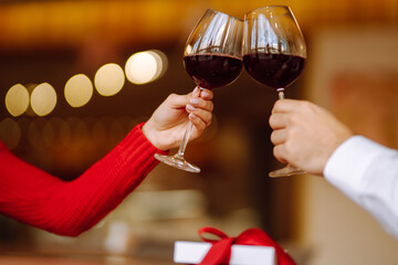 Clinking glasses with red wine. Romantic dinner. Valentines day, romantic date and holidays concept.