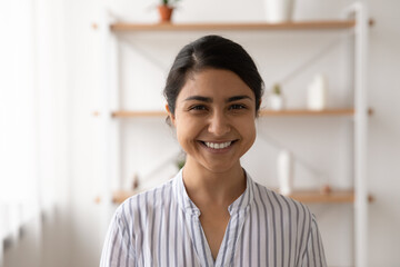 Headshot portrait of pretty smiling millennial female of indian ethnicity housewife student employee in casual closing. Profile picture of happy young mixed race lady looking at camera posing at home