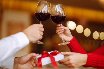 Clinking glasses with red wine. Romantic dinner. Valentines day, romantic date and holidays concept.